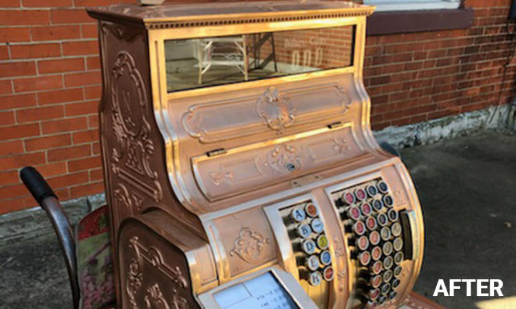 Brass antique cash register that is clean and shiny.